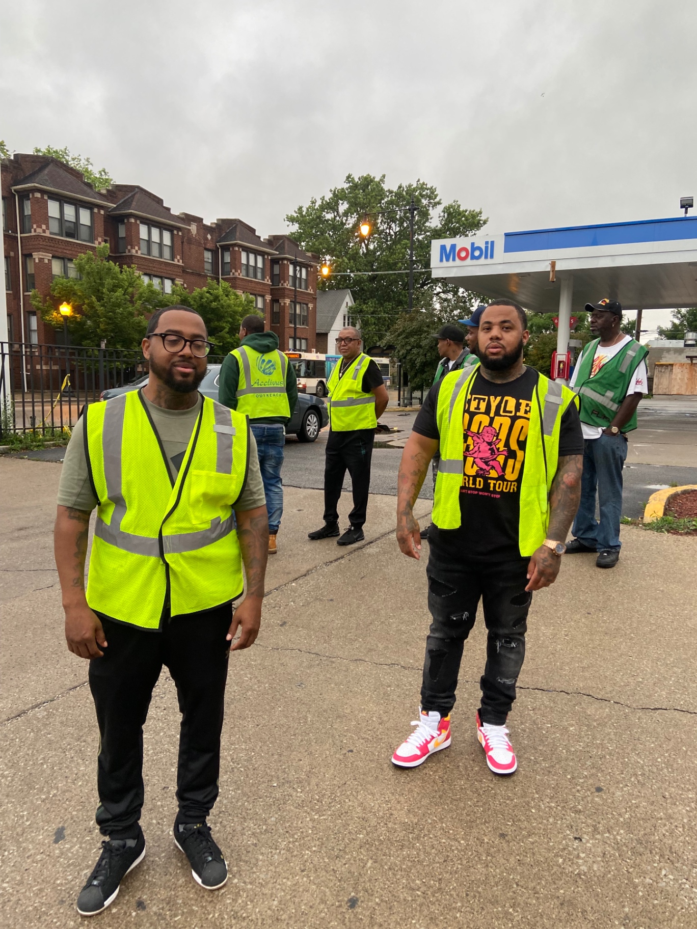 Second Chance Living team members in safety vests handing out coffee and donuts on a neighborhood corner